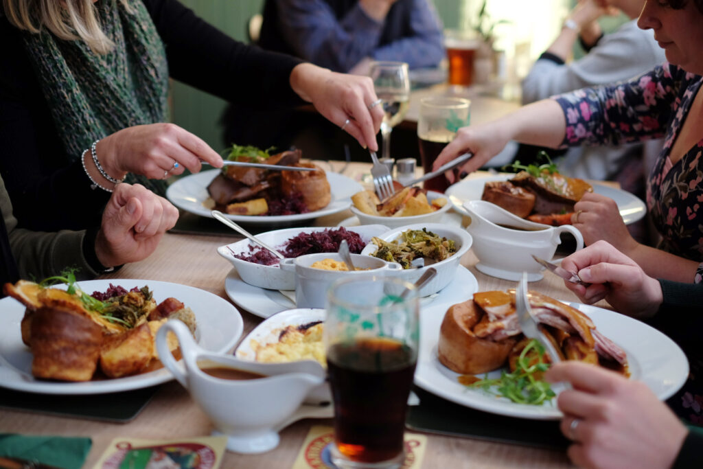 People tucking into a Sunday roast and enjoying a beer at the railway arms pub in Norfolk